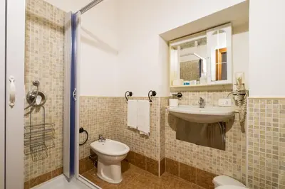 a bathroom with a sink and a toilet and a mirror at B&B Addauru in Palermo