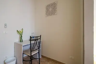a room with a desk and a chair next to a wall at B&B Addauru in Palermo