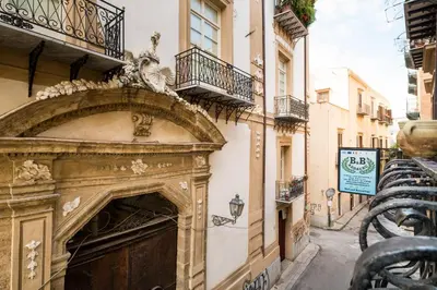 an old building with an arch on a street at B&B Addauru in Palermo