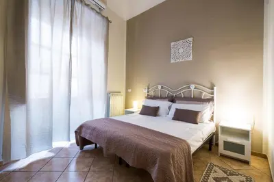 a bedroom with a bed and a large window at B&B Addauru in Palermo
