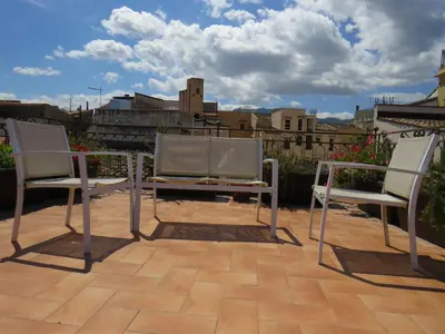 two chairs and a table on a patio at Sunny loft with terrace and Jacuzzi in the city centre in Palermo