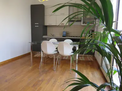 a kitchen with a table with four chairs and a plant at Sunny loft with terrace and Jacuzzi in the city centre in Palermo