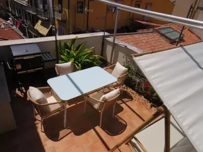 a table and chairs on top of a balcony at Sunny loft with terrace and Jacuzzi in the city centre in Palermo