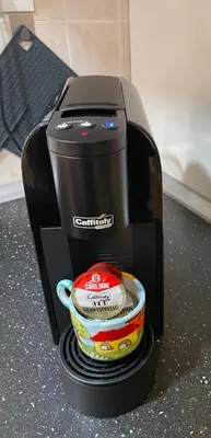 a black coffee maker with a cup on a counter at Casa Mia in Altavilla Milicia