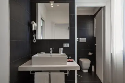 a bathroom with a sink and a mirror and a toilet at Palco Rooms&Suites in Palermo