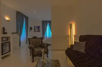 a living room with a couch and a chair at Palco Rooms&Suites in Palermo