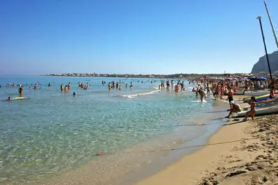 a group of people in the water at a beach at VILLA BUTTERFLY 1 sea and history in Capaci