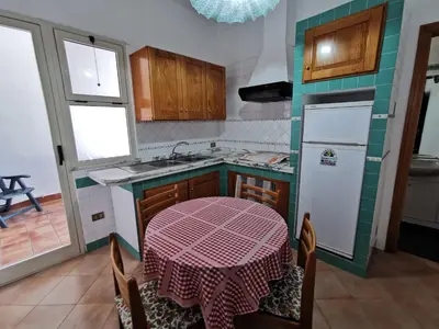 a kitchen with a table and a sink and a refrigerator at Mondello Vista Mare in Mondello