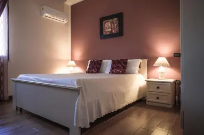 a bedroom with a large bed with two lamps on it at Piano del Re rooms in Partinico
