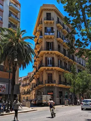 two people riding motorcycles in front of a tall building at Casa Del Vicolo Apartament in Palermo
