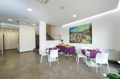 a dining room with purple tables and white chairs at Le Camere del Crimiso in Castellammare del Golfo