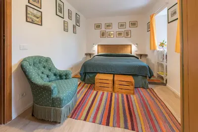 a bedroom with a bed and a chair and a rug at Il Glicine La Piana dei Colli in Mondello