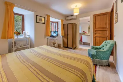 a bedroom with a bed and a chair at Il Glicine La Piana dei Colli in Mondello