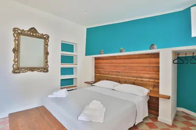 a bedroom with a bed with a mirror and towels at Storie di Palermo in Palermo