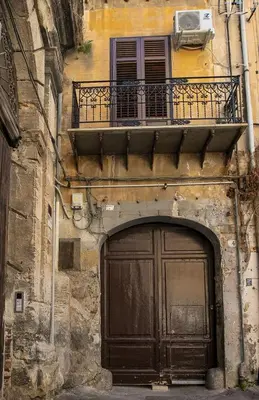 an old building with a large door and a balcony at Storie di Palermo in Palermo