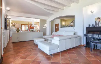 a living room with a white couch and a piano at Villa Musasealdoge in Partinico