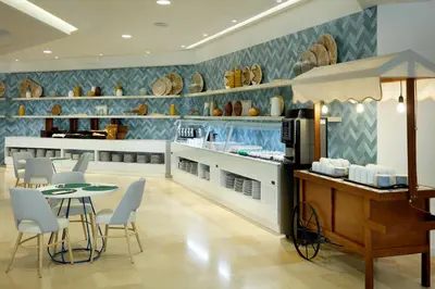 a restaurant with a table and chairs in a room at The Signature Level at Grand Palladium Sicilia Resort & Spa in Campofelice di Roccella