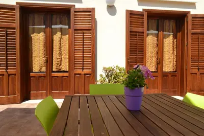 a wooden table with a potted plant on a patio at La Giara San Vito Lo Capo in Castelluzzo