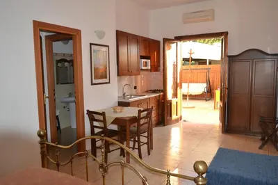 a kitchen with a table and chairs in a room at La Giara San Vito Lo Capo in Castelluzzo