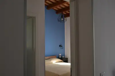 a bedroom with a bed and a blue wall at La Giara San Vito Lo Capo in Castelluzzo