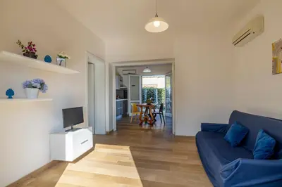 a living room with a blue couch and a television at Casa Vacanza Azzurra in San Vito lo Capo