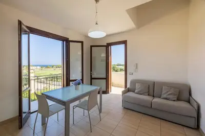 a living room with a table and a couch at Casa Vacanza Azzurra in San Vito lo Capo