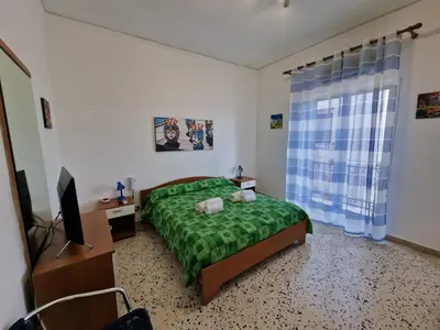 a bedroom with a green bed and a television at Mondello vista in Mondello
