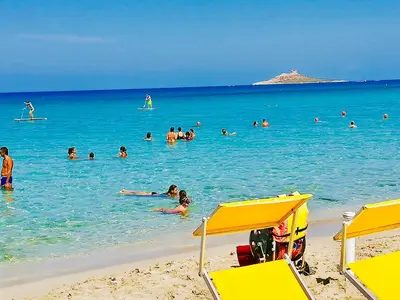 a group of people in the water at the beach at Casa vacanze Isolotto in Isola delle Femmine