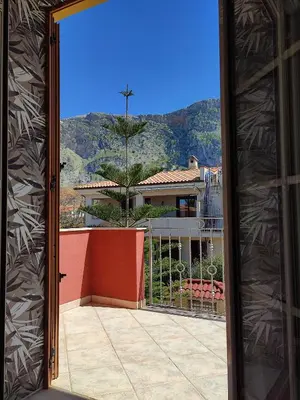 a door leading to a balcony with a view of a house at Casa vacanze Isolotto in Isola delle Femmine