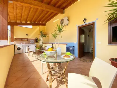 a kitchen with a table with a bowl of fruit on it at Solemar Sicilia - Casa Maria in Santa Flavia