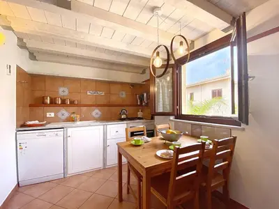 a kitchen with a wooden table and a window at Solemar Sicilia - Casa Maria in Santa Flavia