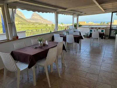 a restaurant with tables and chairs with a view at Triskell Camere & Relax in Castelluzzo