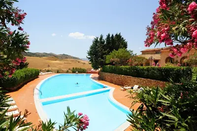 a swimming pool in a garden with flowers at Villa Dafne in Alia