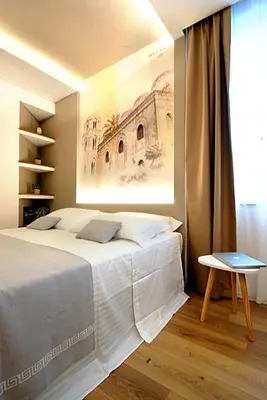 a bedroom with a bed with a painting on the wall at BURNÌA Sicily Holiday House in Palermo