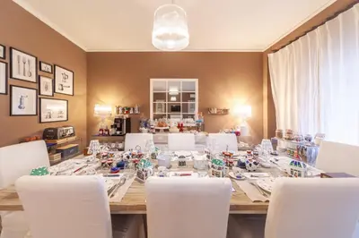 a dining room with a long table and white chairs at Maison de Famille in Palermo