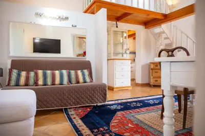 a living room with a couch and a tv at Solemar Sicilia - Casa Olivia in Santa Flavia