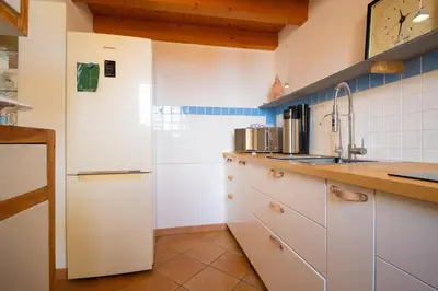 a kitchen with white cabinets and a sink at Solemar Sicilia - Casa Olivia in Santa Flavia