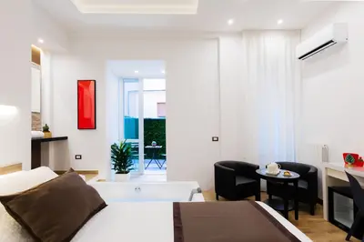 a bedroom with a bed and a living room at Lighea aqua suites and breakfast in Palermo