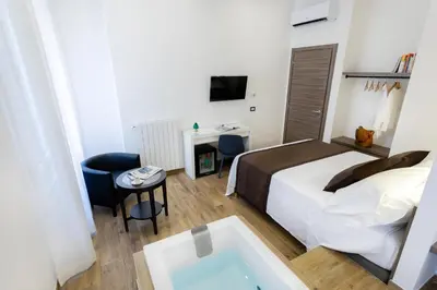 a hotel room with a bed and a tub at Lighea aqua suites and breakfast in Palermo