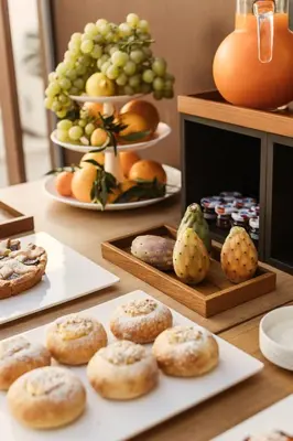 a table topped with plates of cookies and fruit at Hotel Tannure in San Vito lo Capo