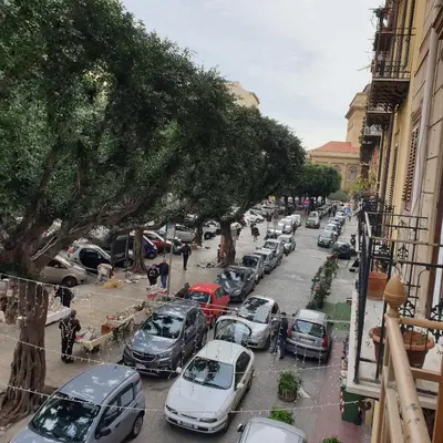 a row of cars parked on a city street at Opera Prima 28 in Palermo