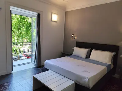 a bedroom with a large bed with green pillows at Opera Prima 28 in Palermo