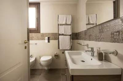 a white bathroom with a toilet and a sink at Conte Federico Apartments in Palermo