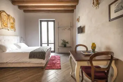 a bedroom with a bed and a desk and a table at Conte Federico Apartments in Palermo
