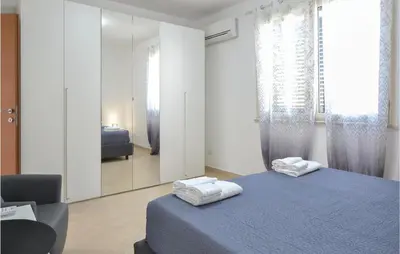 a bedroom with a blue bed and a mirror at Appartamento Darling in Isola delle Femmine