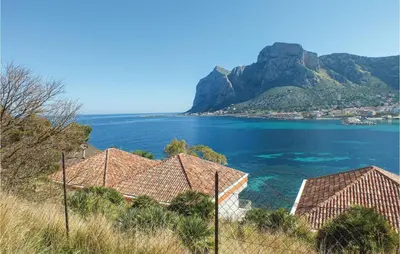 a group of houses on a hill next to the ocean at Appartamento Darling in Isola delle Femmine