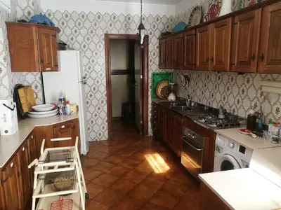 a kitchen with wooden cabinets and a white refrigerator at VILLA LEA in Mondello