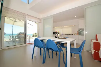 a kitchen with a white table and blue chairs at La Dimora di Venere in Alcamo