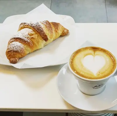 a pastry and a cup of coffee on a table at Vanity SPA in Balestrate