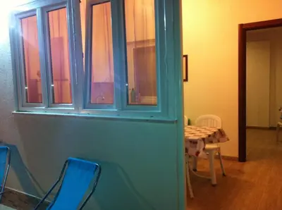 a room with a table and chairs and a blue door at Casa Vacanze Mari in San Vito lo Capo